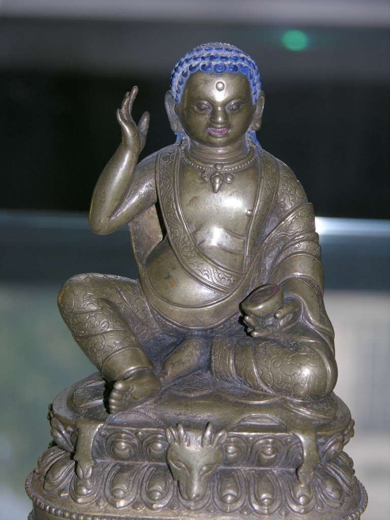 British Museum Top 20 Buddhism 18 Milarepa 18. Milarepa  Tibet, 18C AD or earlier, 12.8cm high. Milarepa ('the cotton clad', 1052-1135) is one of the most loved saints of Tibet. He is especially remembered for the huge number of songs he composed. He is considered a founder of the Kargyupa order of Tibetan Buddhism, though he himself was a disciple of Marpa. In this bronze image he is recognized by the right hand held up to his ear, indicating that he is reciting one of his celebrated poems or songs.